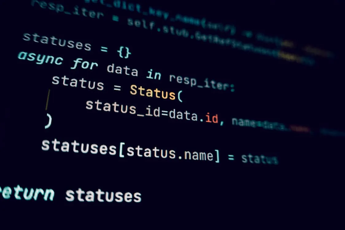 Dark monitor showing programming code in a dim workspace, representing a developer terminal running Claude Code.