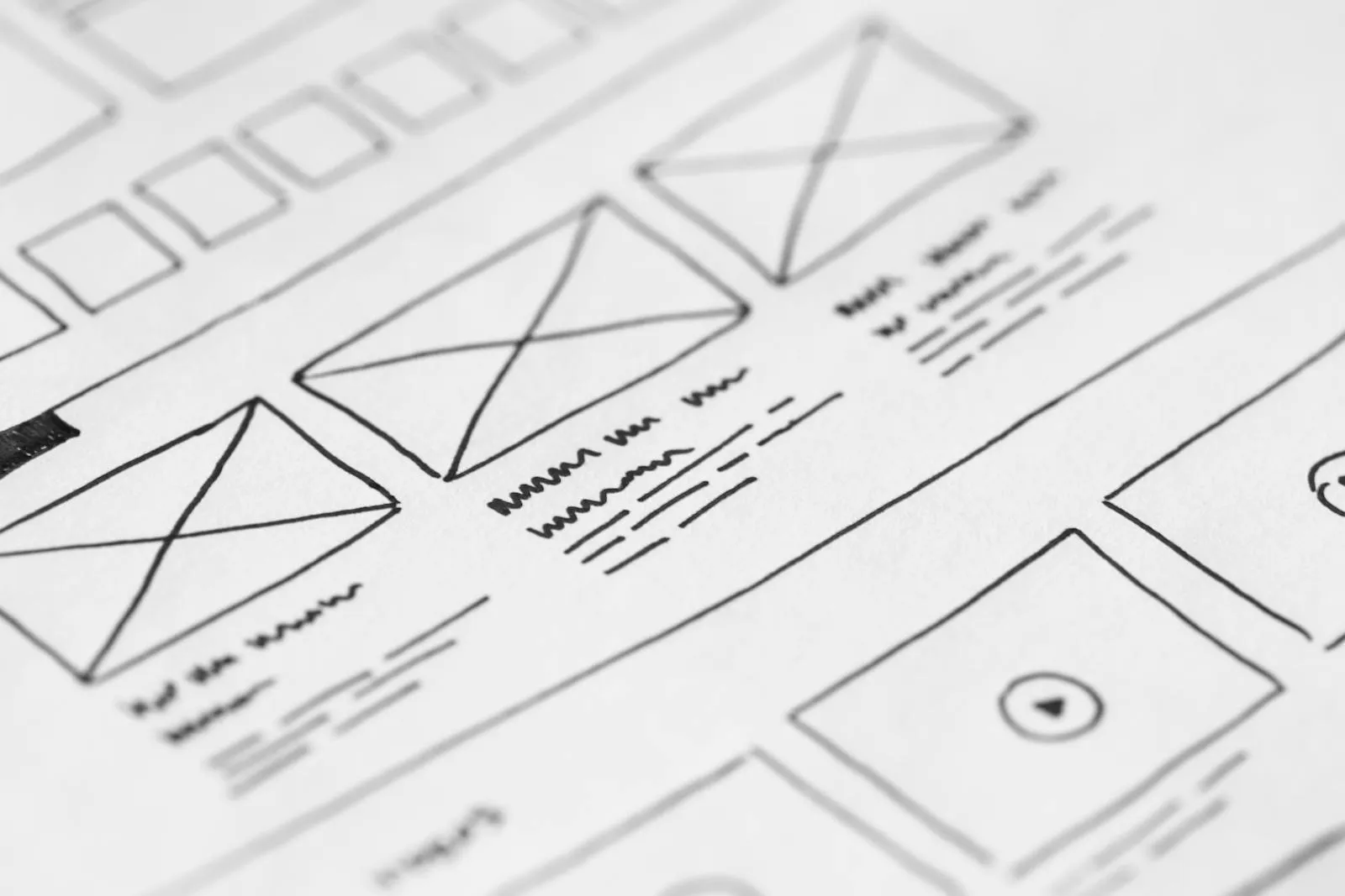 Hand-drawn wireframe sketches on paper next to a phone, the unglamorous side of design system work.